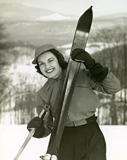Woman holding skis on slope