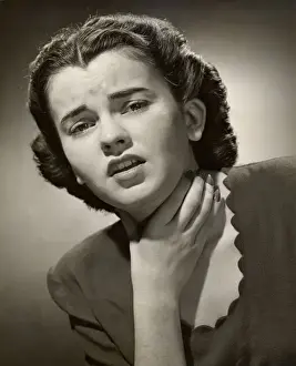 Woman holding sore throat