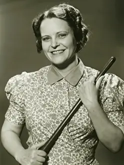 Nightstick Prints: Woman holding stick, posing in studio, (B&W), portrait