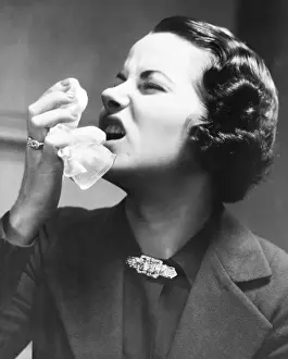 One Mid Adult Woman Only Prints: Woman holding tissue, sneezing (B&W)