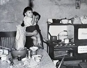 Slum Prints: Woman Holds Child While Cooking;Poverty