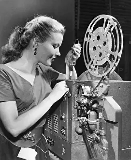 Bloomfield Prints: Woman Inserting New Lamp into Projector