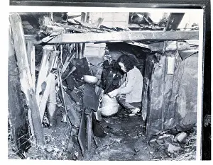 Homelessness Prints: Woman Kneels In Her Ramshackle Shelter
