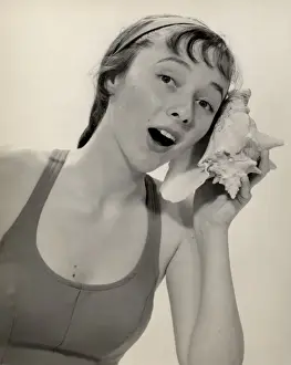 Woman listening to conch shell
