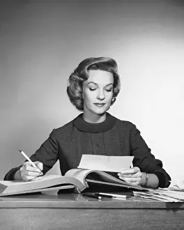 Businesswear Prints: Woman looking at paper, holding pencil