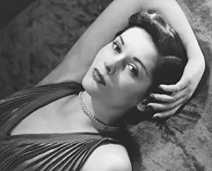 Woman lying on bed, (B&W), close-up, portrait