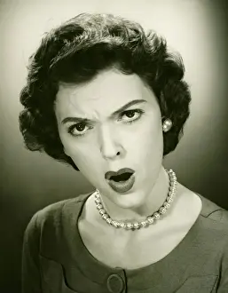 One Mid Adult Woman Only Prints: Woman making face in studio, (B&W), close-up, portrait