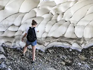Woman Mountaineer on a glacier snow on a break using the mobile phone
