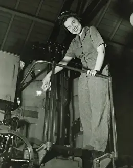 Bending Down Prints: Woman operating machine in factory, (B&W), portrait, low angle view