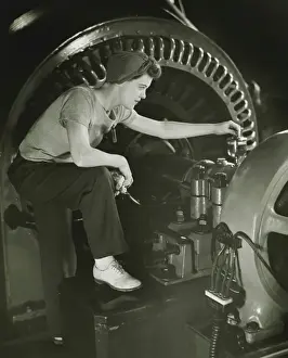 One Mid Adult Woman Only Prints: Woman operating machine in factory, (B&W)