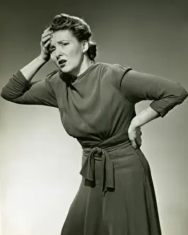 Woman in pain clutches head and back