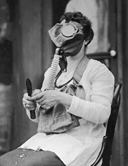Woman peeling potato, wearing gas mask (B&W)