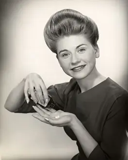 Woman with pill bottle and pills in hand