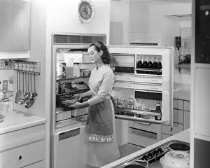 Refrigerator Prints: Woman Placing Food Into Refrigerator
