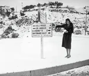 Directional Sign Prints: Woman Pointing to Sign in Snowy California