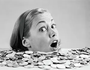 One Mature Woman Only Prints: Woman pulling funny face, up to her neck in coins