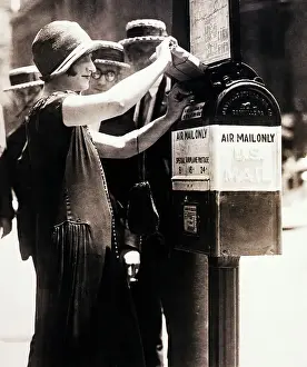 Woman Putting Package into First Airmail
