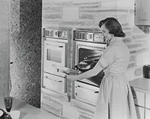 Woman Putting Roast in New Automatic Oven
