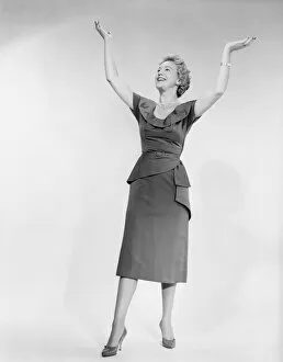 1960s Fashion Collection: Woman raising arms, studio shot