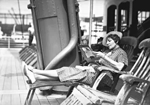 Woman reading magazine on cruiser deck, (B&W)