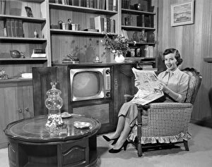 Woman relaxing at home with newspaper