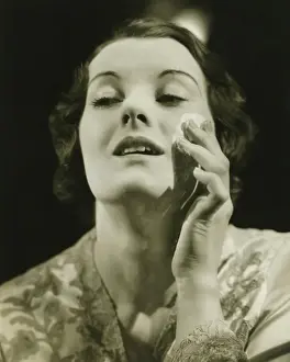 Removing Prints: Woman removing make up in studio, (B&W), close-up