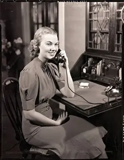 woman-seated-desk-talking-