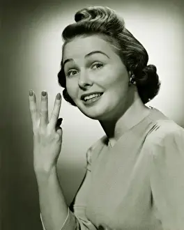 Raised Eyebrow Prints: Woman showing three fingers in studio, (B&W), portrait