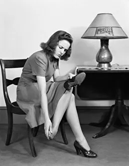 Retrofile Gallery: Woman sitting in chair, rubbing her feet. (Photo by H. Armstrong Roberts / Retrofile / Getty)