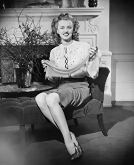 House Interior Prints: Woman sitting on chaise longue, holding scarf, (B&W), portrait