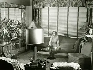 1950s Style Prints: Woman sitting on couch in opulent living room, (B&W)