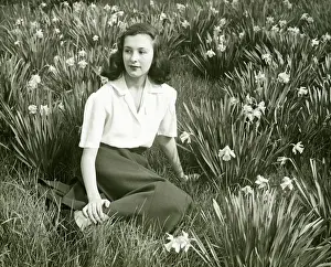 Daffodil Prints: Woman sitting on grass among blooming daffodils, (B&W), (Portrait)