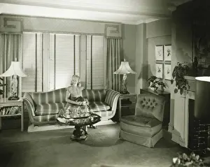 Interior Space Prints: Woman sitting on sofa in stylish living room, (B&W)