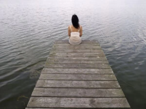 Back Gallery: Woman sitting on a wooden pier at a lake, Mecklenburg Lake District
