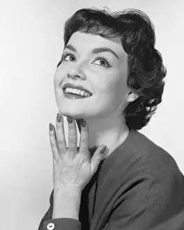 Woman smiling, posing with hand under chin