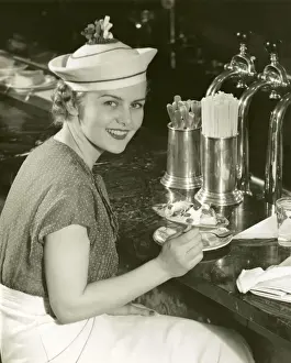 Woman at soda fountain with banana split
