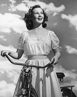16 17 Years Prints: Woman standing with bicycle