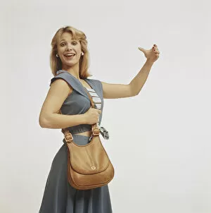 Woman standing with handbag and gesturing, close-up