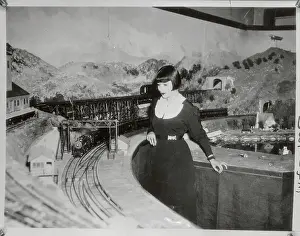 Woman Standing by Large Toy Train Set