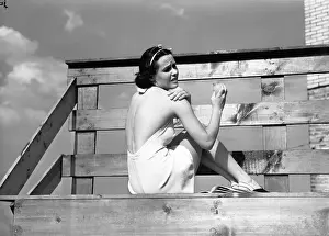 Sunbathing Prints: Woman sunbathing, applying sun cream on shoulder, (B&W)