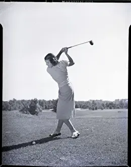 Woman Swinging Golf Club