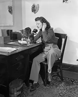 Dairy Prints: Woman talking on phone while cat is sitting on desk