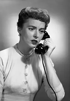 Woman talking on phone in studio, (B&W)