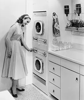 Kitchen Prints: Woman Turning On A Washing Machine