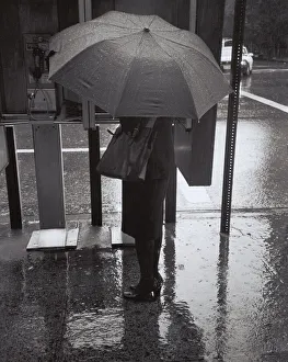 Henri Silberman Collection Gallery: Woman with umbrella talking on public phone in rain