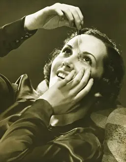 Eyesight Prints: Woman using eye drop in studio, (B&W)