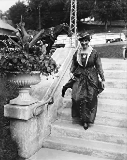 Woman Walking Past Flowers And Down Step