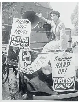 Woman Waving from Atop a Poster Covered Taxi