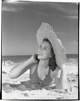 Woman Wearing Straw Hat Lying on Beach