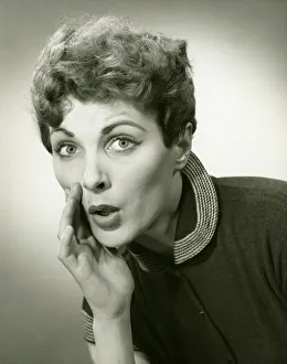 35 39 Years Collection: Woman whispering in studio, (B&W), portrait